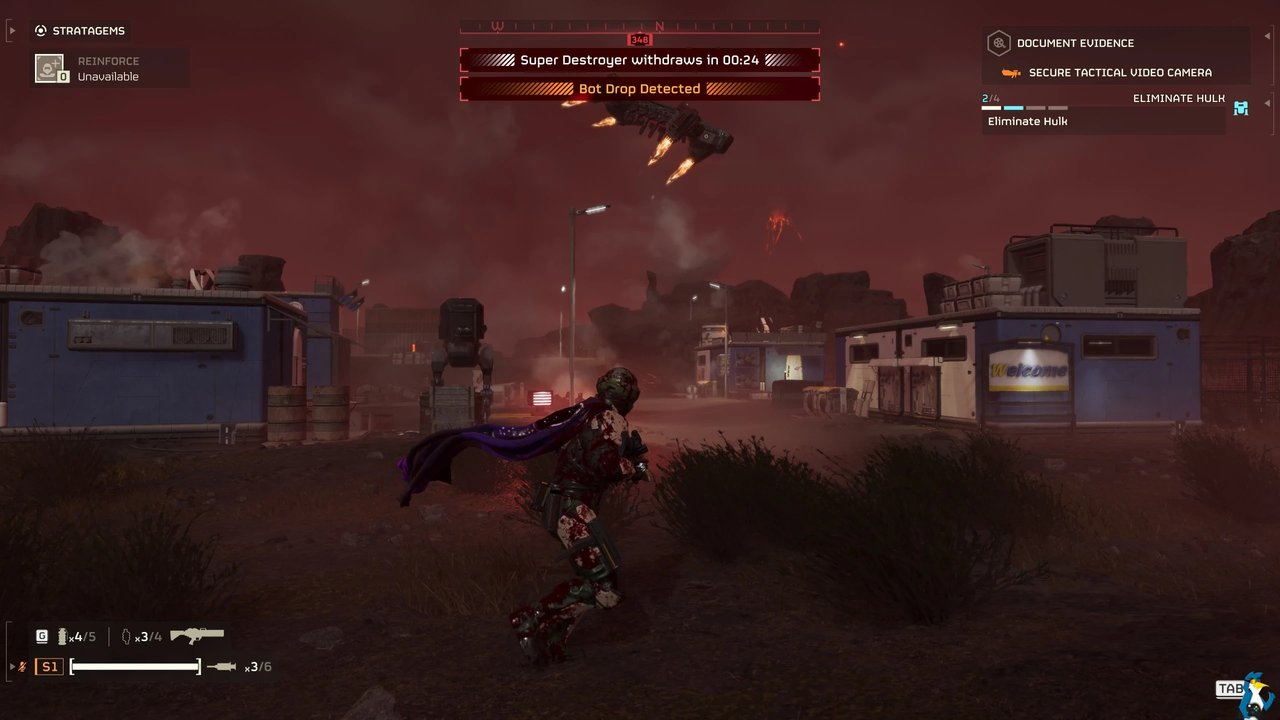 Real Helldivers 2 gameplay screenshot on a red-lit alien planet: a Helldiver in bloodied armour runs toward an industrial outpost while a Super Destroyer withdraws overhead and a Bot Drop is detected.